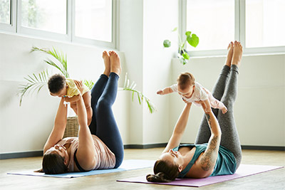 Yogakurs in Halle (Saale) für Mütter mit Baby: Zwei Frauen üben Yoga mit Baby